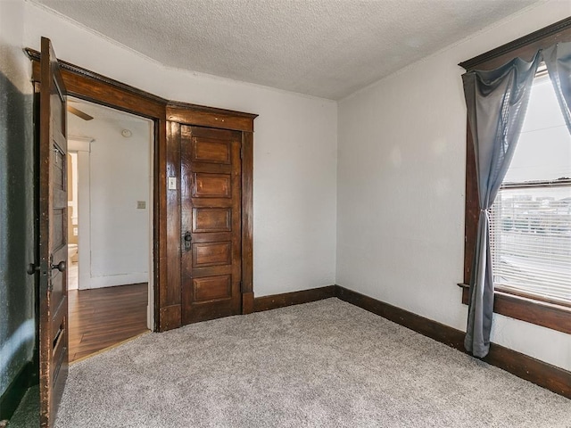 unfurnished room with carpet flooring and a textured ceiling