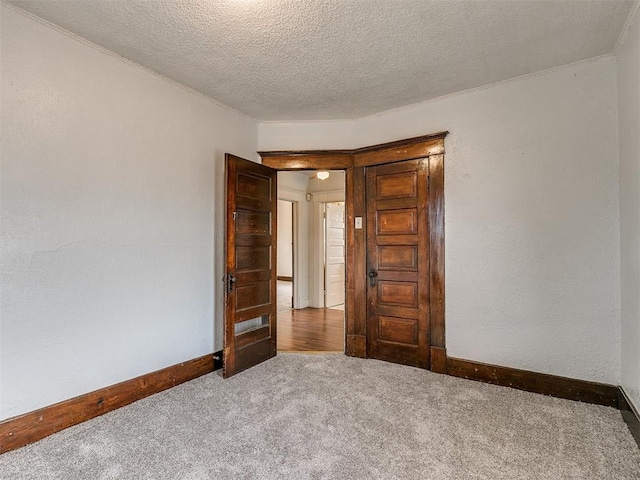 unfurnished room with carpet flooring and a textured ceiling