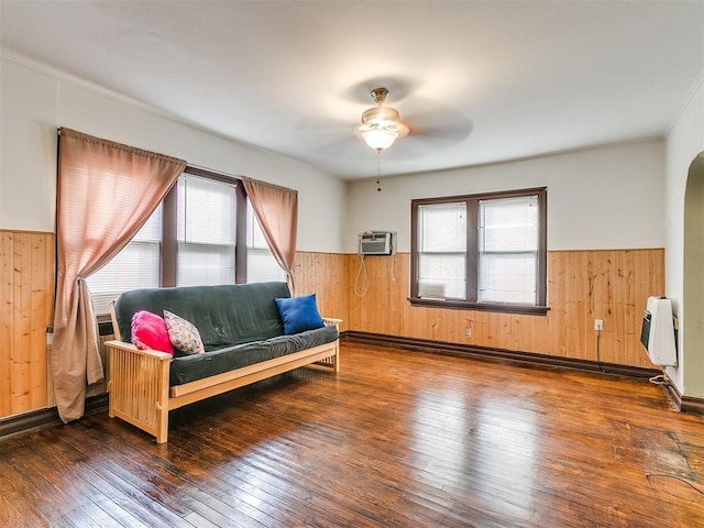 living area featuring ceiling fan, dark hardwood / wood-style flooring, a wall mounted AC, and heating unit