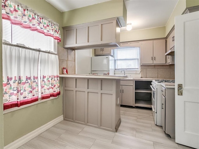 kitchen with gray cabinetry, sink, tasteful backsplash, ventilation hood, and white appliances