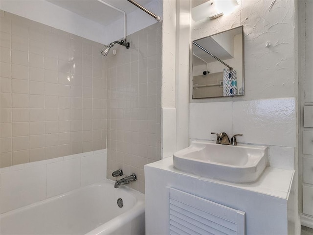 bathroom with vanity and tiled shower / bath