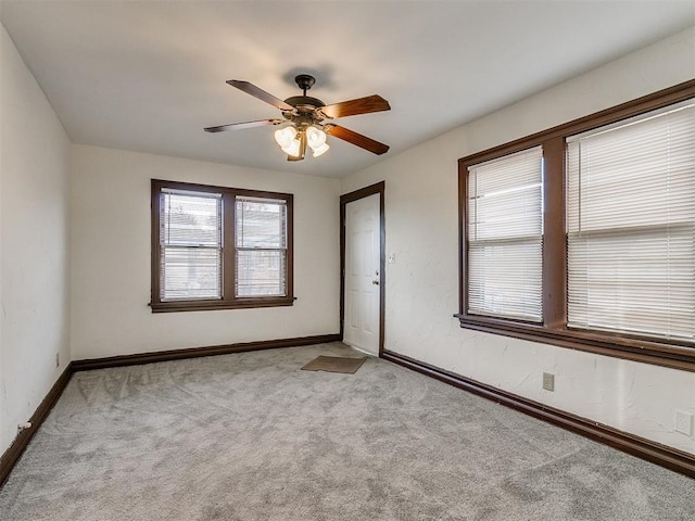 carpeted spare room with ceiling fan