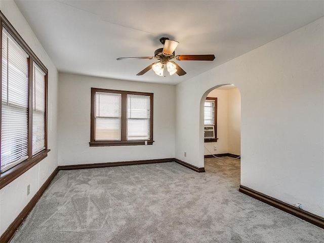 carpeted spare room featuring cooling unit, ceiling fan, and a healthy amount of sunlight