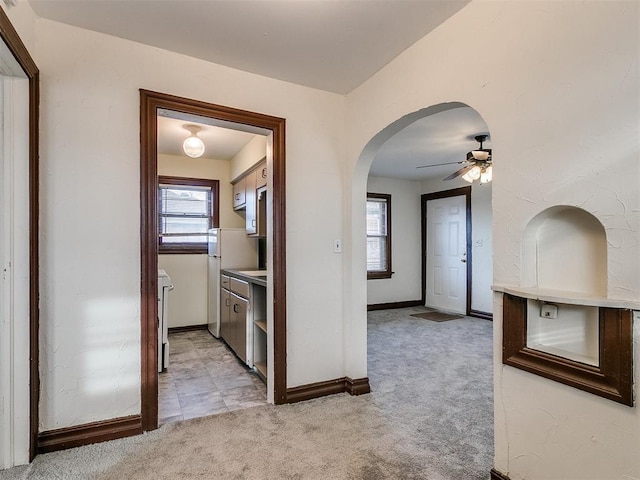 corridor featuring plenty of natural light and light carpet