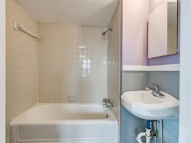 bathroom with tiled shower / bath combo and sink