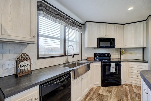 kitchen with sink, light hardwood / wood-style floors, backsplash, and black appliances