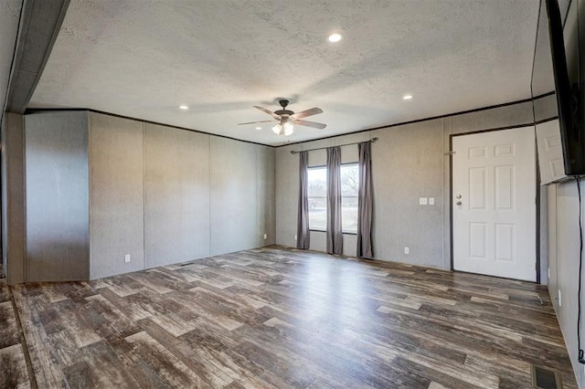 spare room featuring a textured ceiling, ceiling fan, and dark wood-type flooring