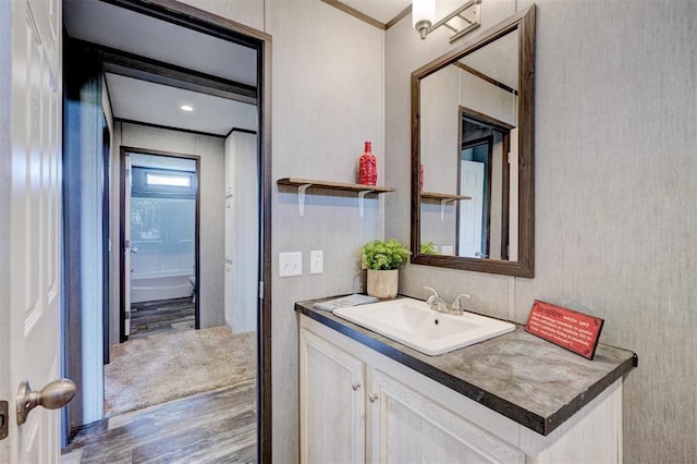 bathroom featuring hardwood / wood-style flooring, vanity, and crown molding