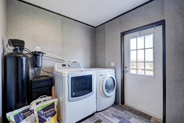 clothes washing area featuring light hardwood / wood-style flooring and washer and dryer