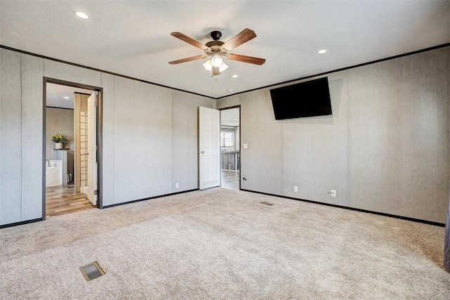 unfurnished bedroom with ceiling fan, light colored carpet, a textured ceiling, and ornamental molding