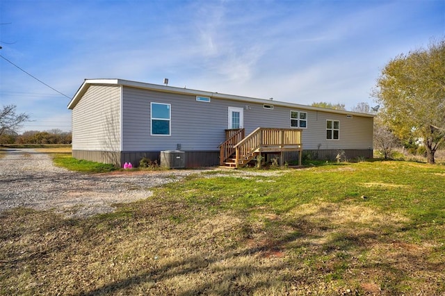 rear view of property with a lawn, a deck, and central air condition unit