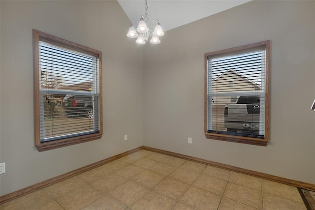 empty room featuring vaulted ceiling, light tile patterned floors, and an inviting chandelier