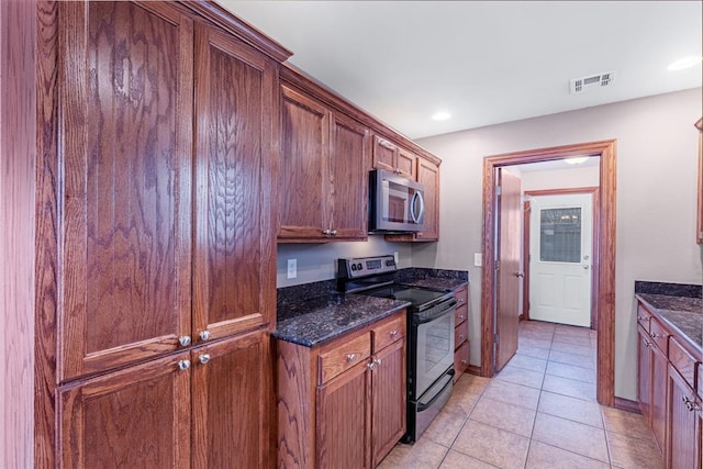 kitchen featuring light tile patterned floors, black range with electric stovetop, and dark stone counters