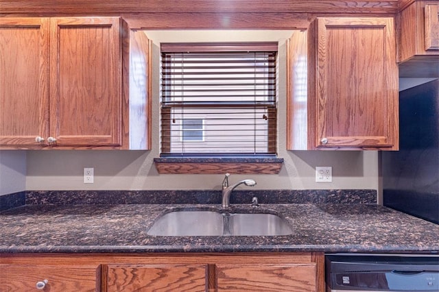 kitchen with black dishwasher, dark stone countertops, and sink