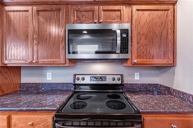 kitchen featuring dark stone counters and electric stove