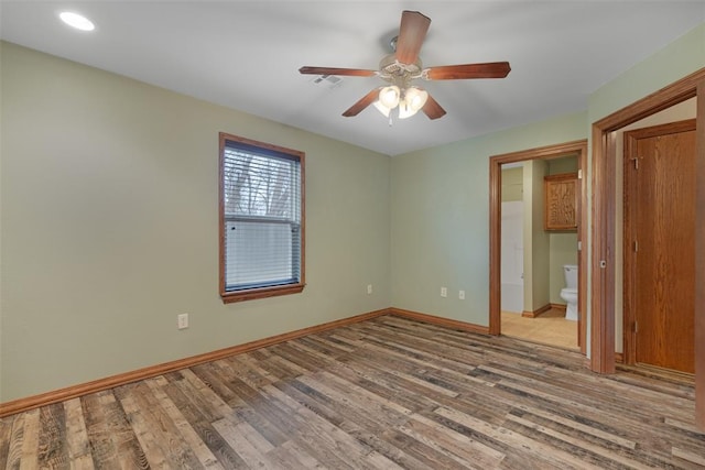 unfurnished bedroom with connected bathroom, ceiling fan, and light wood-type flooring