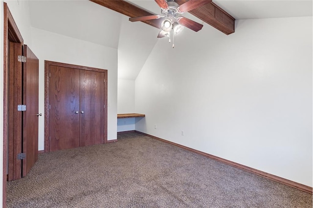 unfurnished bedroom featuring carpet, lofted ceiling with beams, ceiling fan, and a closet