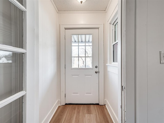 doorway featuring wood walls, light hardwood / wood-style floors, and a textured ceiling