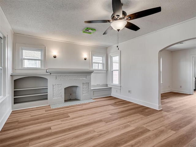 unfurnished living room with a textured ceiling, light hardwood / wood-style floors, and a wealth of natural light