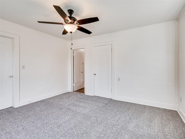 empty room with carpet flooring, ceiling fan, and ornamental molding