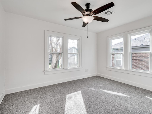 carpeted empty room featuring a wealth of natural light and ceiling fan