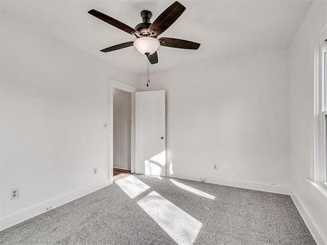 empty room featuring ceiling fan and light colored carpet