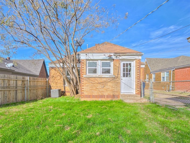 rear view of house featuring a yard and central AC