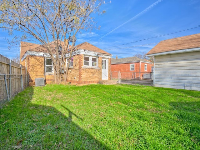 back of property featuring central AC and a lawn