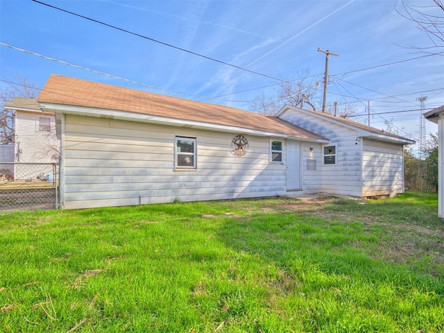 rear view of property featuring a lawn