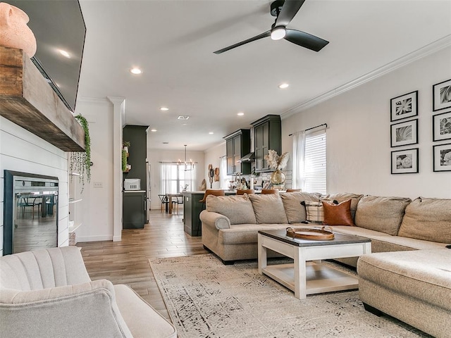 living room with ornamental molding, light wood-type flooring, and recessed lighting