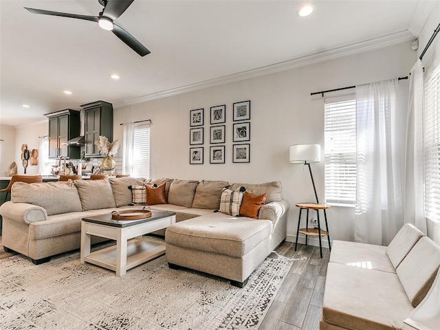 living area with light wood-style flooring, ornamental molding, a ceiling fan, and recessed lighting