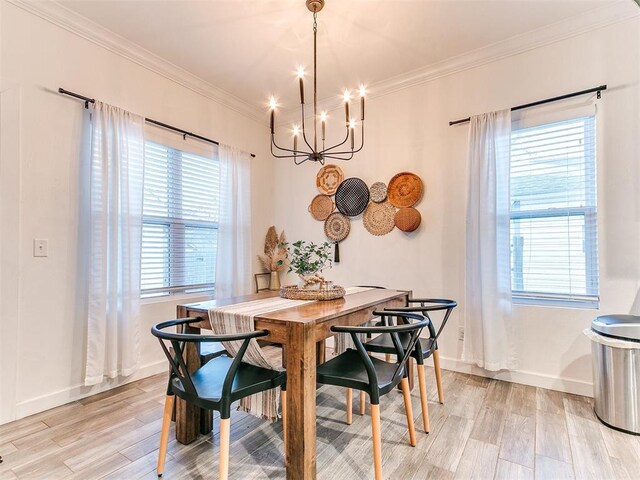 dining area featuring light wood-style floors, a wealth of natural light, and crown molding