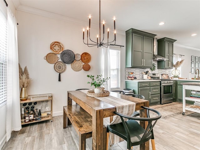 dining area with a chandelier, recessed lighting, baseboards, light wood-style floors, and ornamental molding