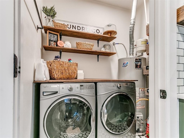 washroom with water heater, laundry area, and washing machine and clothes dryer