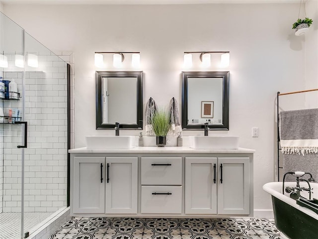 bathroom with double vanity, a shower stall, a freestanding bath, and a sink