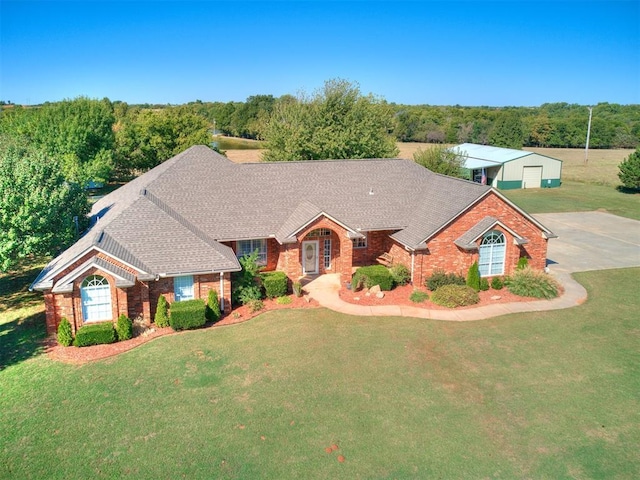 view of front of house with a garage, an outbuilding, and a front lawn