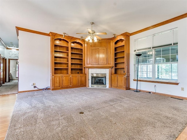 826 S Mustang Rd, Tuttle, OK 73089 - unfurnished living room featuring ornamental molding, a ceiling fan, a fireplace, light carpet, and built in shelves
