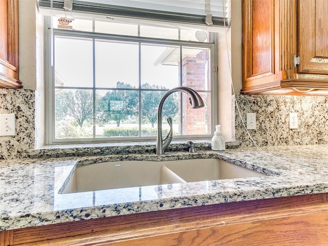 826 S Mustang Rd, Tuttle, OK 73089 - kitchen with brown cabinets, light stone counters, and decorative backsplash