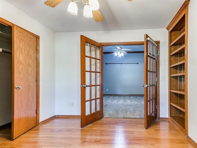 826 S Mustang Rd, Tuttle, OK 73089 - unfurnished bedroom featuring french doors, light wood finished floors, and a ceiling fan
