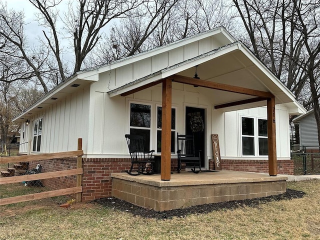 rear view of property featuring covered porch