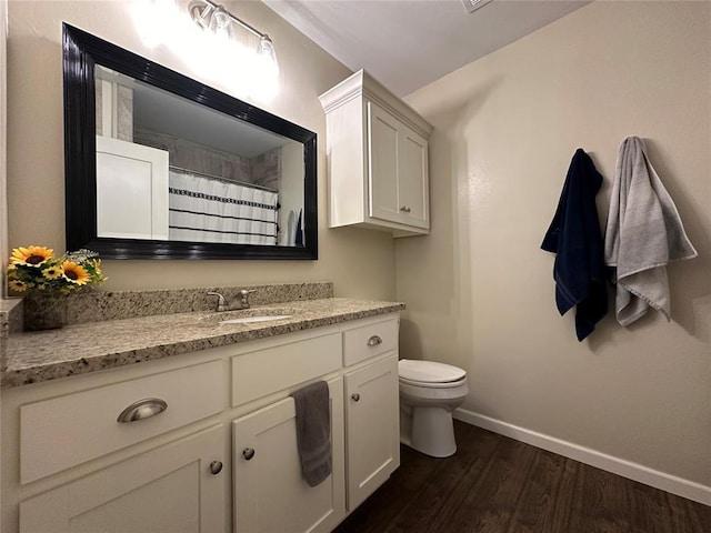 bathroom with vanity, toilet, curtained shower, and hardwood / wood-style floors