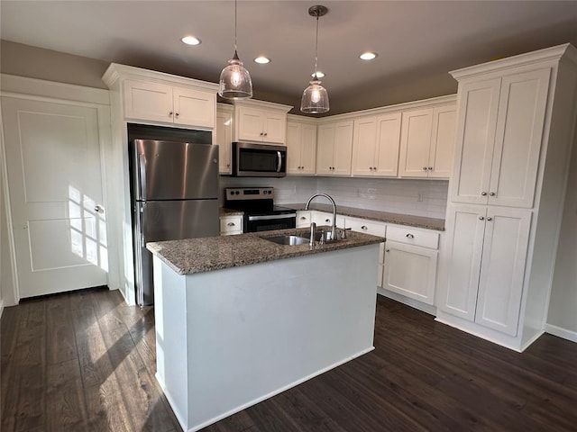 kitchen with sink, appliances with stainless steel finishes, white cabinetry, a kitchen island with sink, and decorative light fixtures