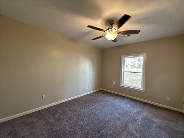 spare room featuring ceiling fan and dark colored carpet