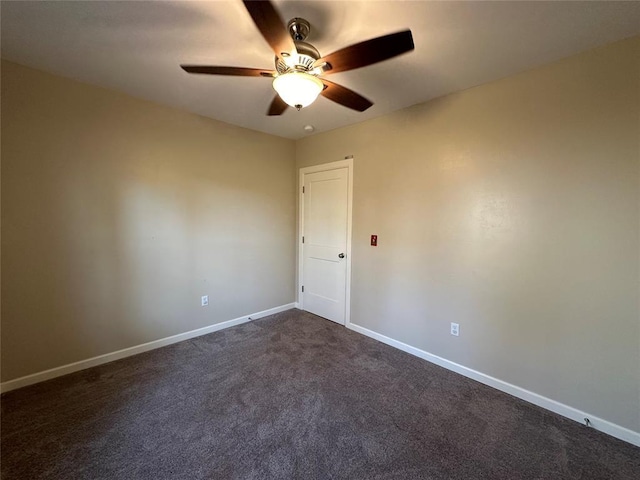 spare room with ceiling fan and dark carpet