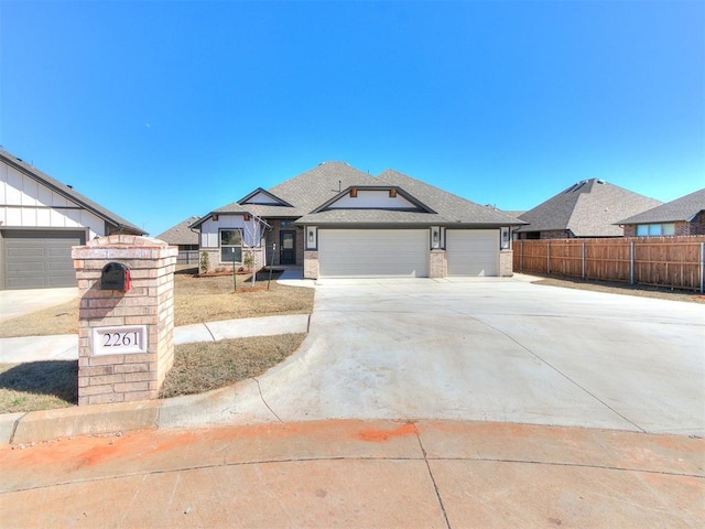 view of front of home featuring brick siding, an attached garage, concrete driveway, and fence