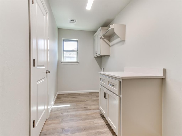 laundry room featuring laundry area, visible vents, light wood-type flooring, and baseboards