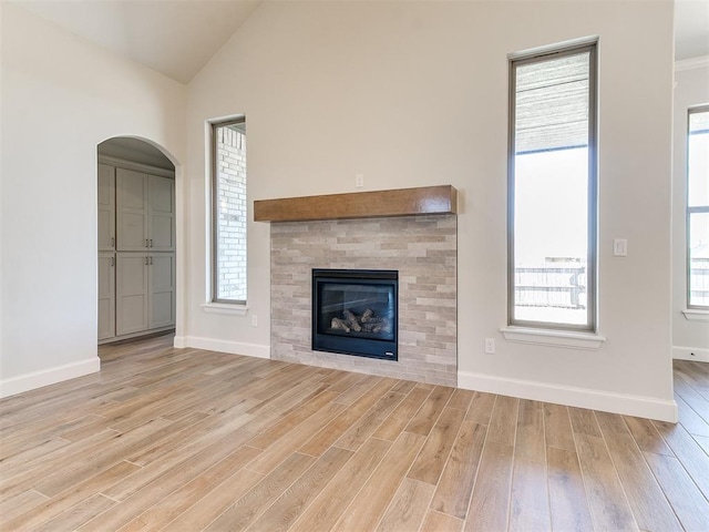 unfurnished living room with plenty of natural light, lofted ceiling, and wood finished floors