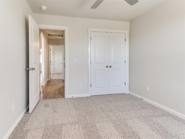 unfurnished bedroom with a closet, visible vents, carpet flooring, and baseboards