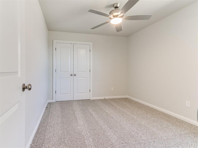 unfurnished bedroom featuring a closet, baseboards, carpet, and ceiling fan