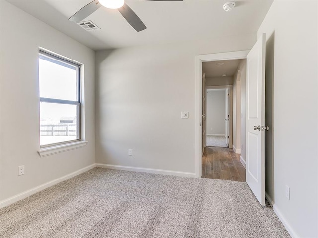 unfurnished bedroom with a ceiling fan, baseboards, visible vents, and carpet floors